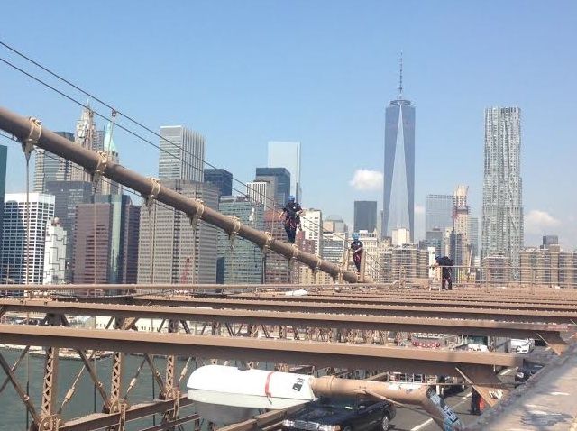 Police climb up to the Manhattan-side tower on the Brooklyn Bridge to capture the flag.